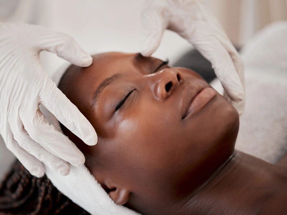 Black woman, face and sleeping in spa facial for beauty skincare, massage or relaxing in treatment. Calm African American female dreaming in luxury physical therapy, zen or relaxation at beauty clinic